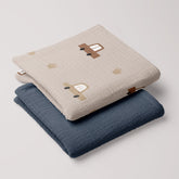 Cars muslin swaddle and navy blue muslin blanket stacked together